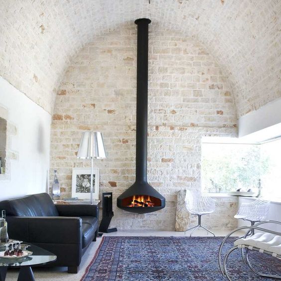 Salones con pared de piedra y chimenea